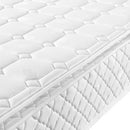 Close-up of a white mattress with quilted pattern and brand logo.
