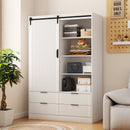 White wardrobe with sliding door in a room with a plant and sofa.