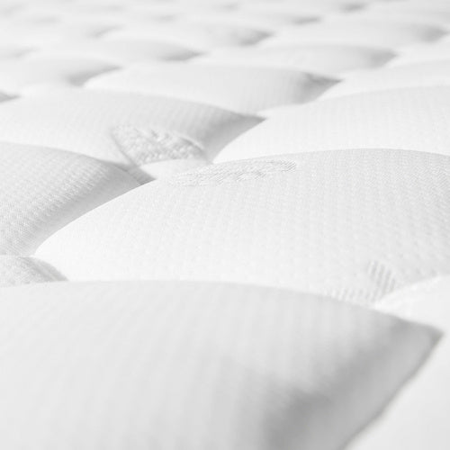 Close-up of a white mattress with quilted design