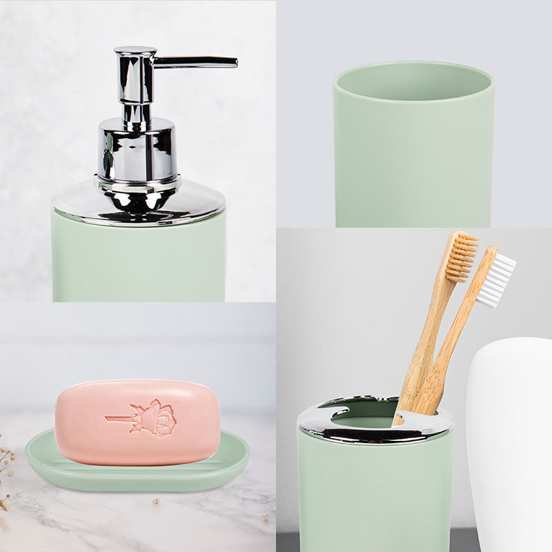 Household supplies, household cleaning products, cleaning products Bathroom set with green soap dispenser, toothbrush holder, and pink soap bar on a white background