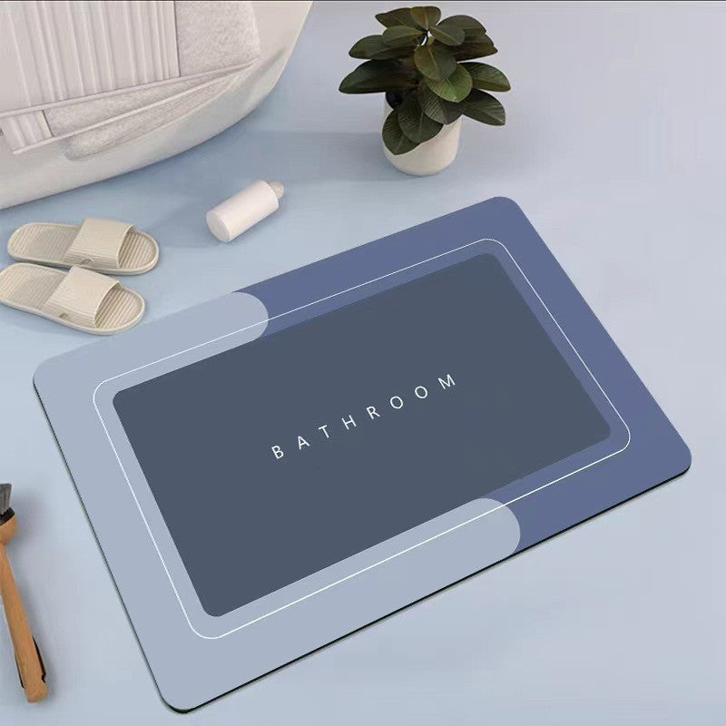 Mat, comforters, Blue bathmat with 'Bathroom' text on a light blue surface with slippers and a plant.