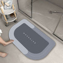 Mat, comforters, grey bathmat with 'Bathroom' text on a bathroom floor