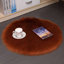 Mats, bed sheets, comforters, round brown fur rug with a cup, saucer, and book on a grey floor.