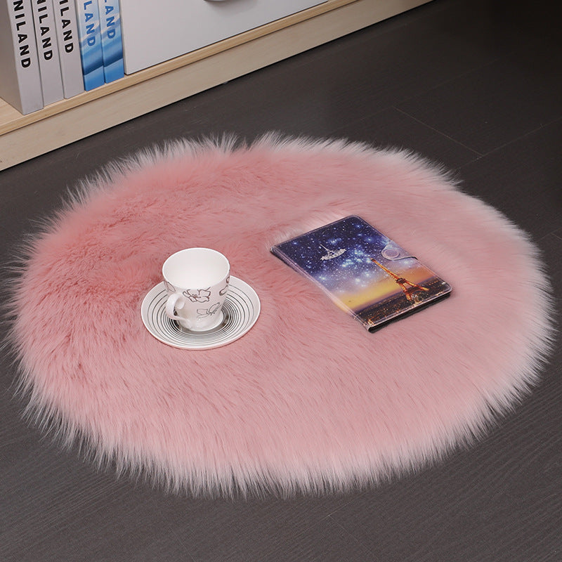 Mats, bed sheets, comforters, Pink fluffy rug on a dark floor with a phone and cup on top