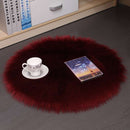 Mats, bed sheets, comforters, round red fluffy rug with a cup, saucer, and book on a dark floor.