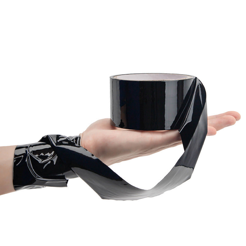 Household supplies, household cleaning products, cleaning products Person wearing a black vinyl glove holding a cylindrical black object.