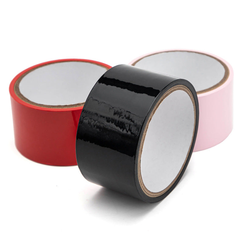 Household supplies, household cleaning products, cleaning products Three rolls of tape in red, black, and pink on a white background
