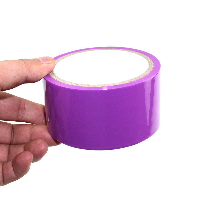 Household supplies, household cleaning products, cleaning products Purple tape held by a hand on a white background