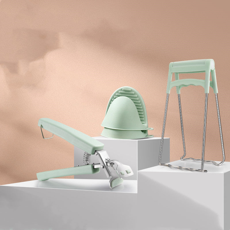 Household supplies, household cleaning products, cleaning products Set of green kitchen tools including a whisk, spatula, and stand on a neutral background