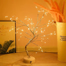 Home decor, room decor, Decorative LED tree with lights on a wooden surface against an orange wall.