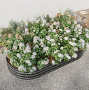 Garden pots, outdoor decor, garden ornaments, Floral arrangement in a black metal planter on a gray surface