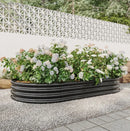 Garden pots, outdoor decor, garden ornaments, Floral garden in a black metal planter against a white lattice wall.