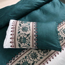 Mat, bed sheets, comforters, Teal pillow with floral embroidery on a matching fabric background