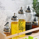 Household supplies, household cleaning products, cleaning products Set of glass oil and vinegar bottles with metal nozzles on a wooden tray.