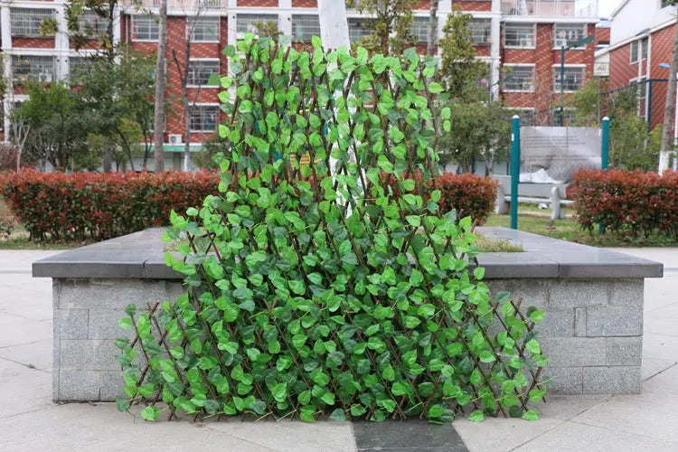 Garden pots, outdoor decor, garden ornaments, Artificial green screen fence in an outdoor setting with buildings and trees in the background.
