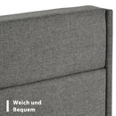 Gray upholstered headboard with text 'Weich und Bequem' on a white background